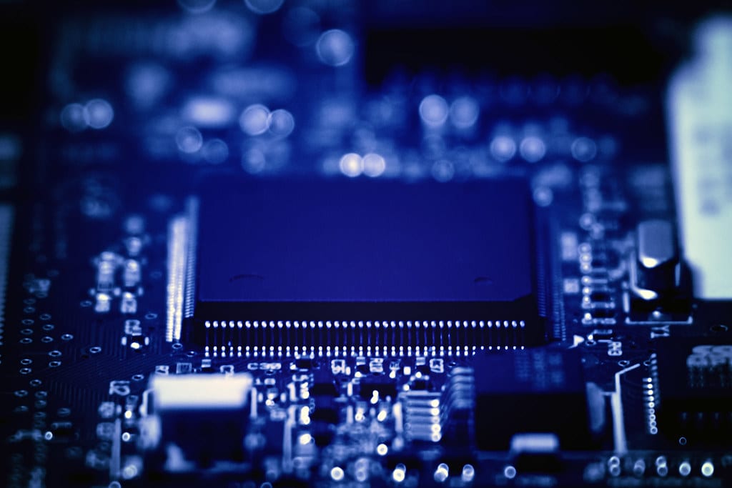 Placa eletrônica de um aparelho em detalhe, com chip e trilhas